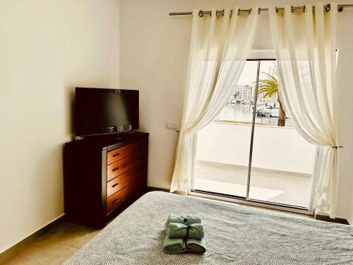 a bedroom with a bed and a television and a window at Marina view studio in Lagos town center sea view in Lagos