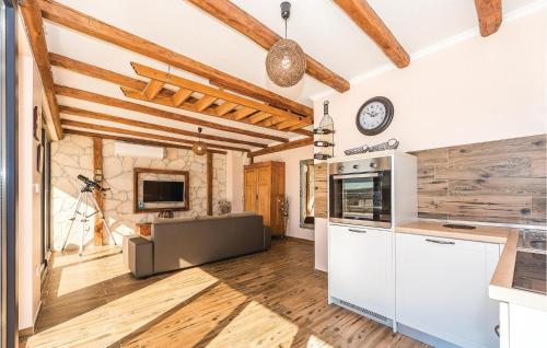 a kitchen with white cabinets and a clock on the wall at Four-Bedroom Holiday Home In Kijevo in Kijevo