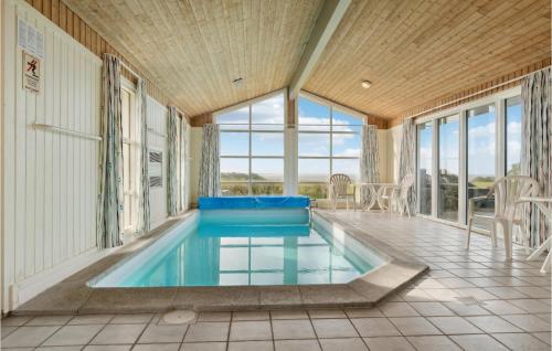 a swimming pool in a house with windows at Stunning Home In Vestervig With Sauna in Vestervig