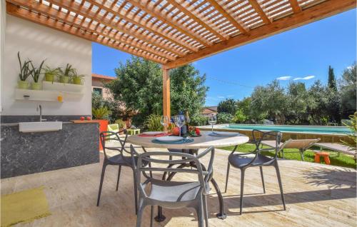 a patio with a table and chairs under a wooden pergola at Gorgeous Home In Trabia With Wifi in Trabia