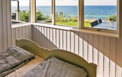 a bench in a room with windows and the ocean at Three-Bedroom Holiday Home In Allingabro in Rygård Strand