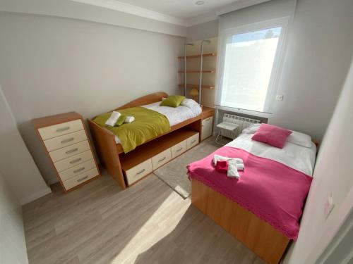 a small bedroom with two beds and a window at Urdaibai Luxy in Pedernales