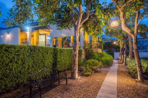 a park bench in front of a house with trees at Venice Beach Village Hua Hin Pool Villa in Cha Am