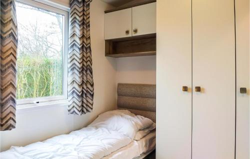 a bedroom with a bed and a window at 2 Bedroom Amazing Home In Heinkenszand in Heinkensand