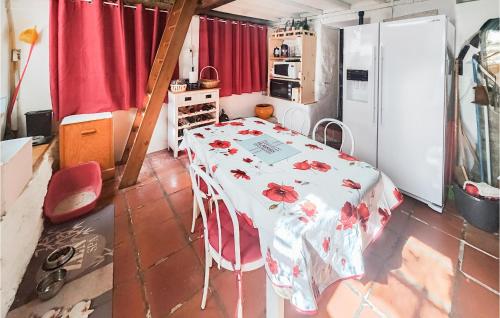 une cuisine avec une table et un réfrigérateur blanc dans l'établissement Lovely Home In Cesseras, à Cesseras