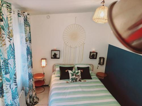 Schlafzimmer mit einem Bett mit einer blauen und weißen Bettdecke in der Unterkunft Cozy Apartment, Airport CDG Exhibition Parc 14 min in Tremblay En France