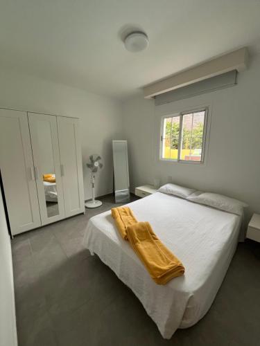 a bedroom with a bed with a yellow blanket on it at SUNNY CARMELITO DELUXE in Mogán