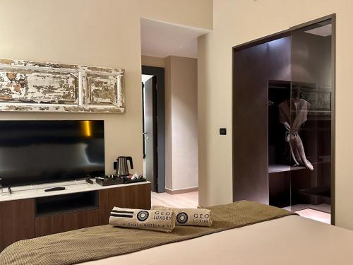 a bedroom with a bed and a large television at Hotel Capo San Vito by Geocharme in San Vito lo Capo