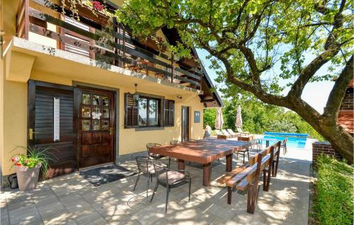 drewniany stół i krzesła siedzące poza domem w obiekcie Beautiful Home In Bedenica With Sauna w mieście Bedenica