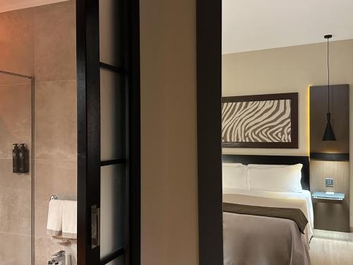 a hotel room with a bed and a shower at Hotel Capo San Vito by Geocharme in San Vito lo Capo
