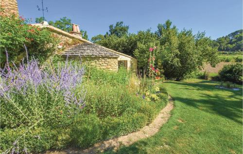 un jardin avec des fleurs violettes et un bâtiment dans l'établissement Lovely Home In Malaucene, à Malaucène