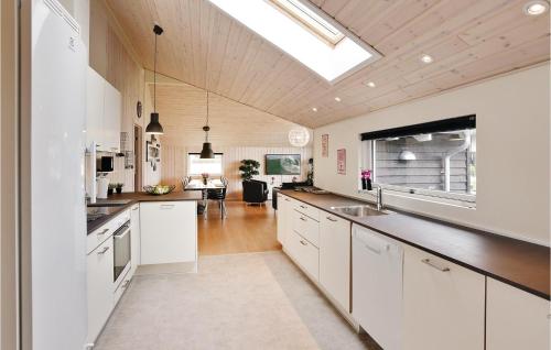 a kitchen with white cabinets and a skylight at Nice Home In Stege With Sauna in Stege