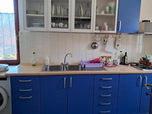 a kitchen with blue cabinets and a sink at Casa Vacanza Margherita in Minucciano