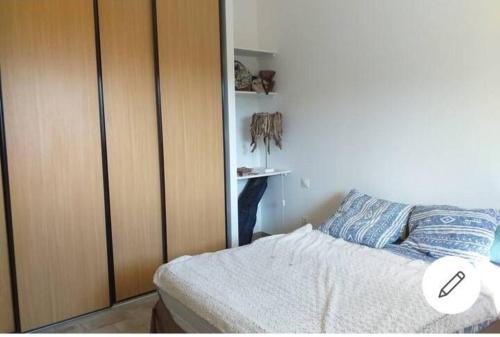 une chambre avec un lit et une armoire en bois dans l'établissement Appartement T2 Belvedere campomoro, à Portigliolo