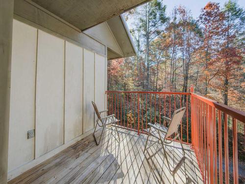 two chairs on a balcony with trees in the background at NEW LISTING Sasquatch Lodge F in Gatlinburg