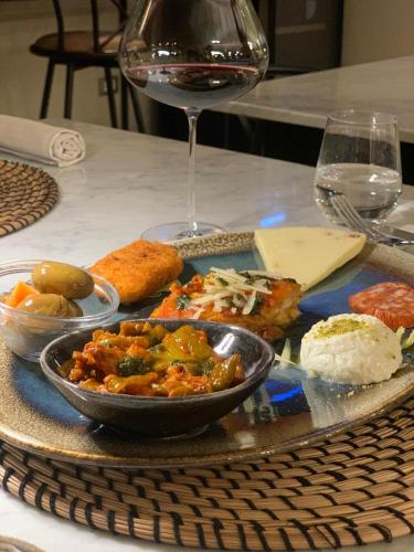 a plate of food on a table with a glass of wine at Villa Felicia in Noto