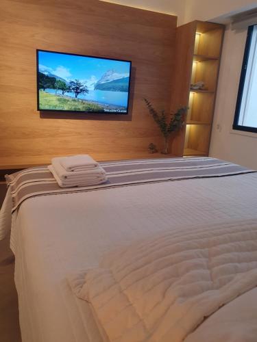 a bedroom with a bed with a flat screen tv on the wall at Oh Barrancas in Buenos Aires
