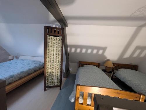 a bedroom with two beds and a lamp in it at La dépendance, petite maison au calme 1Chambre in Vallon-sur-Gée