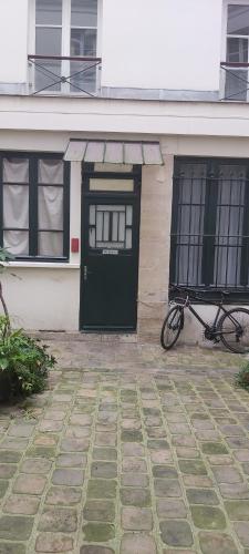 un vélo garé devant une maison avec une porte dans l'établissement Studio prés du gare du l'Est, à Paris