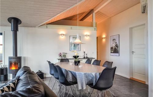 a dining room with a table and chairs and a couch at Holiday Home Arvidvej Hvide Sande Denm in Bjerregård