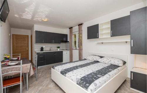 クラヴィツァにあるStunning Apartment In Krvavicaのベッドとテーブルとキッチンのある寝室