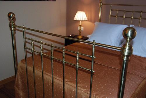 a bed with a metal frame and a white pillow at Hotel Rural La Cabaña in Palazuelos