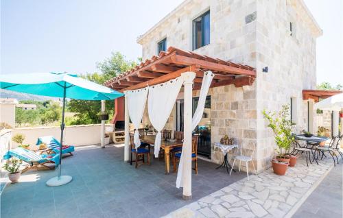 a patio with a table and an umbrella at 4 Bedroom Lovely Home In Cilipi in Čilipi