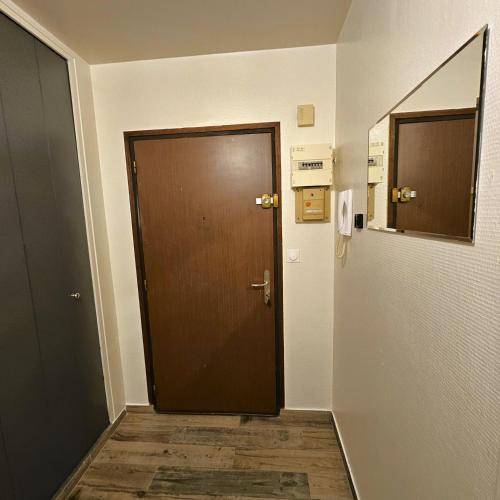 a hallway with a brown door in a room at Studio cosy confort moderne in Vaulx-en-Velin