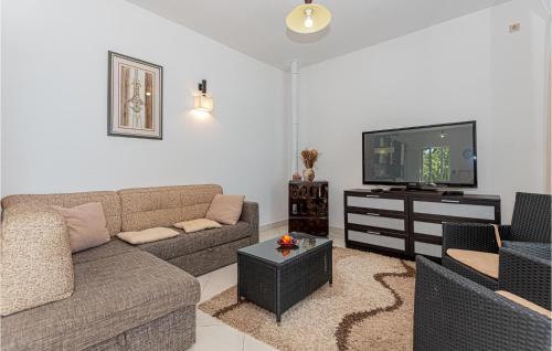 a living room with a couch and a flat screen tv at Six-Bedroom Holiday Home In Sibenik in Šibenik