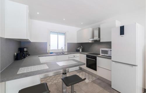une cuisine blanche avec des armoires et des appareils blancs dans l'établissement Amazing Home In Fréjus, à Fréjus