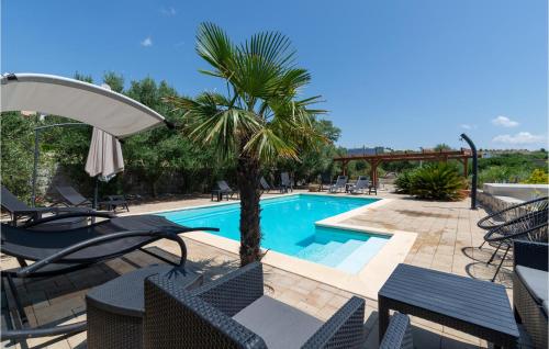 a swimming pool with chairs and a palm tree next to it at Holiday Home Rtina 24 in Rtina