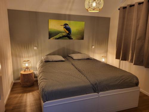 una camera da letto con un letto e un quadro sul muro di Sundaville bij Posbank Veluwe a Eerbeek