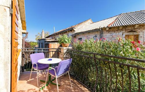 a patio with two chairs and a table on a balcony at Cozy Home In Zminj With Kitchen in Žminj