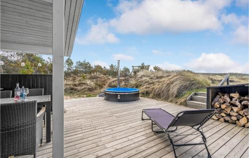 a deck with a hot tub and a chair at Holiday Home Johnsvej Thisted V in Klitmøller