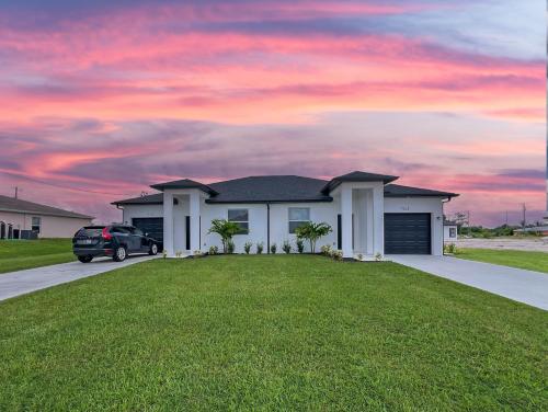 a house with a car parked in a driveway at Lysias Resort in Lehigh Acres