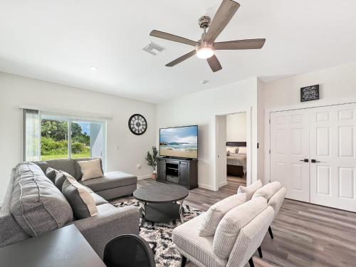 a living room with a couch and a ceiling fan at Lysias Resort in Lehigh Acres