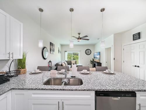 a kitchen with a sink and a living room at Lysias Resort in Lehigh Acres