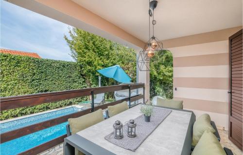 a patio with a table and chairs and a swimming pool at Nice Home In Njivice With Wifi in Njivice