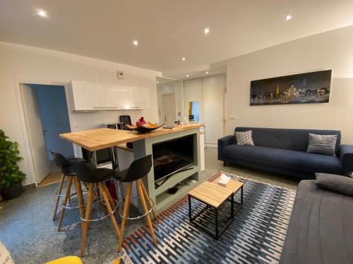 un salon avec un canapé et une cuisine avec une table dans l'établissement Paris City Flat App entier N106 F3, à Paris
