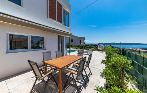 a patio with a wooden table and chairs on a balcony at Amazing Home In Kastel Gomilica in Kaštela