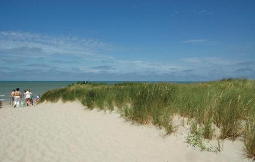 a group of people walking down a sandy beach at Aphrodite in Oostduinkerke