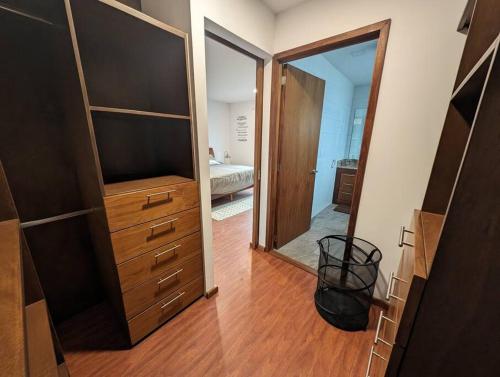 a bedroom with a dresser with a television and a mirror at Depto nuevo cerca de parque FINSA in Sanctórum