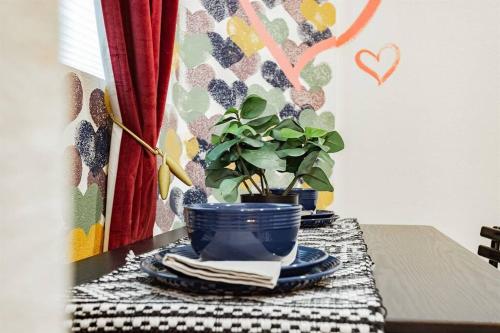 a table with a blue bowl and a potted plant at Star Motel Unit 1- Arts District Haven Modern Las Vegas Vacation Home in Las Vegas