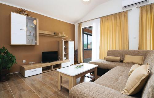 Una sala de estar con un sofá y un televisor. en Beautiful Apartment In Sukosan, en Donje Raštane