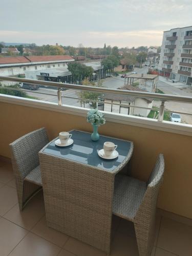 a table and chairs on a balcony with a view at Apartman Fortuna in Požarevac