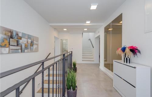 a hallway with white walls and a staircase with plants at Stunning Home In Plano in Plano