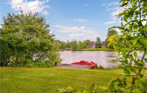 a lake with a dock and a house in the background at Cozy Home In Vlagtwedde With Sauna in Vlagtwedde