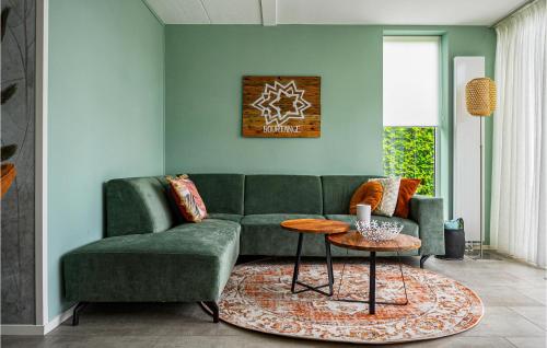 a living room with a green couch and a table at Cozy Home In Vlagtwedde With Sauna in Vlagtwedde