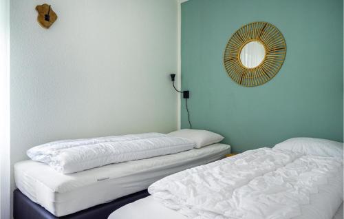 two beds in a room with a mirror on the wall at Cozy Home In Vlagtwedde With Sauna in Vlagtwedde