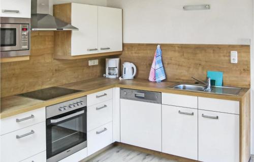 kuchnia z białymi szafkami i zlewem w obiekcie Ansprechende Ferienwohnung w mieście Brixlegg